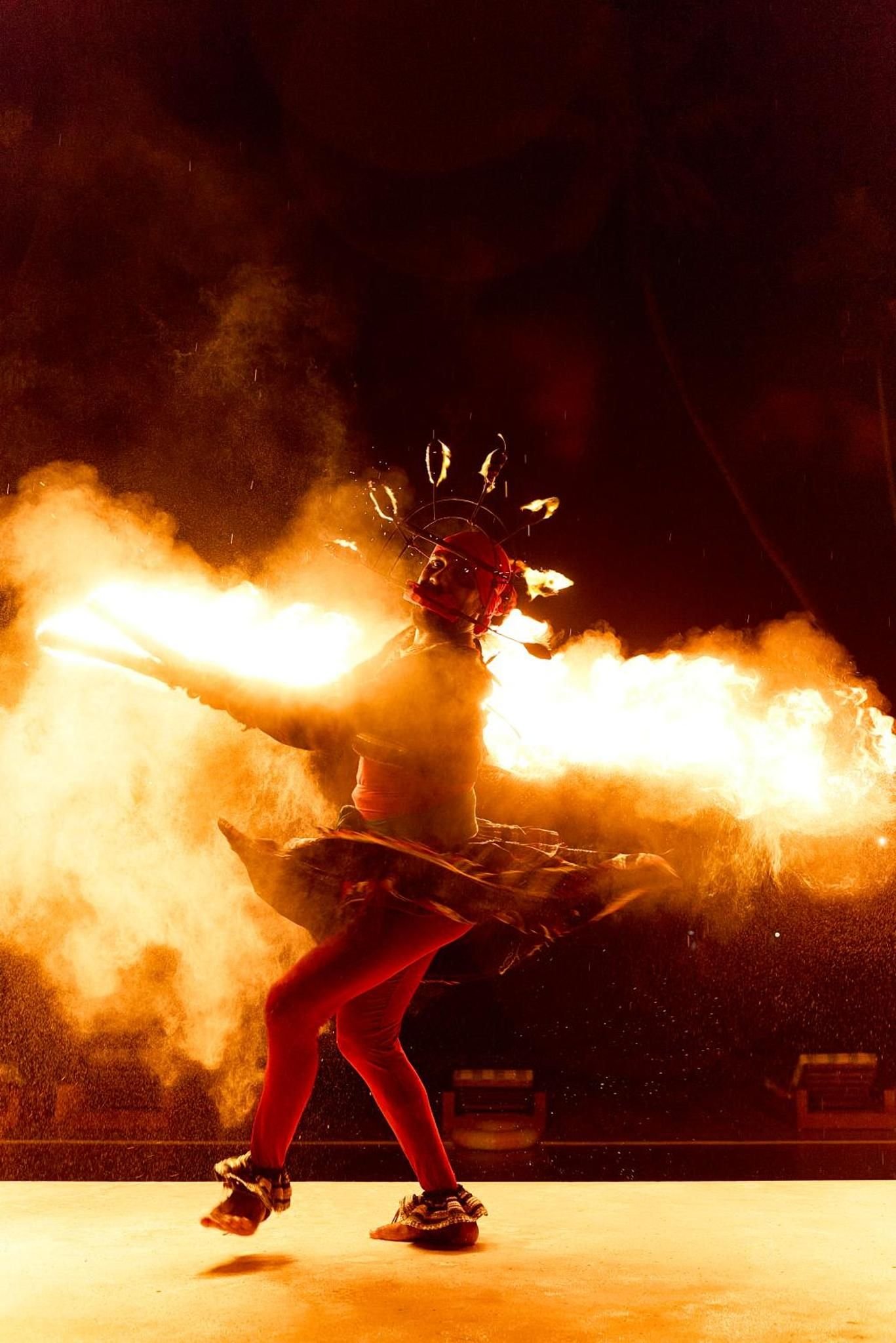 A traditional fire dancer performing at night