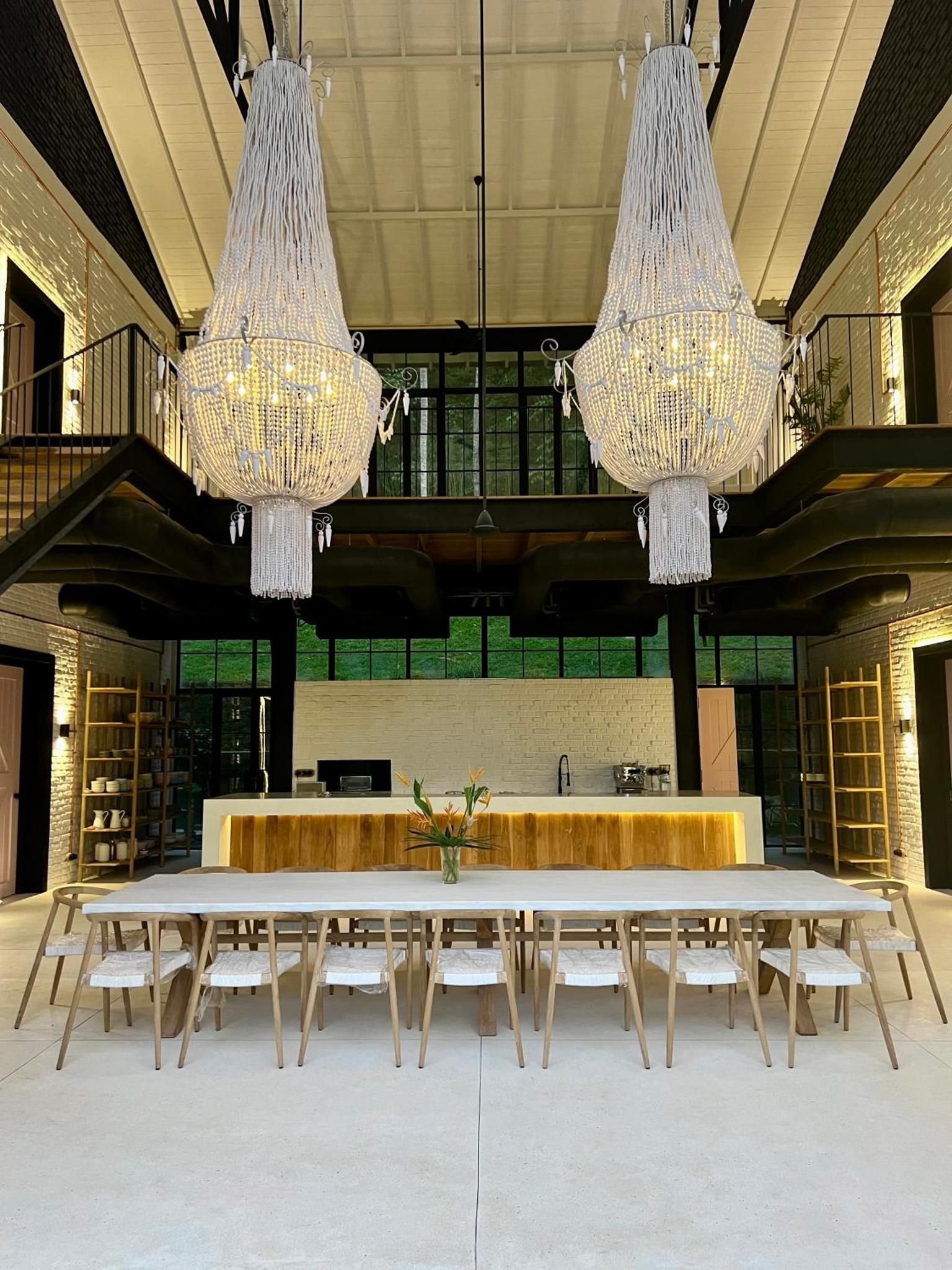 The double-height dining hall with two rattan chandeliers