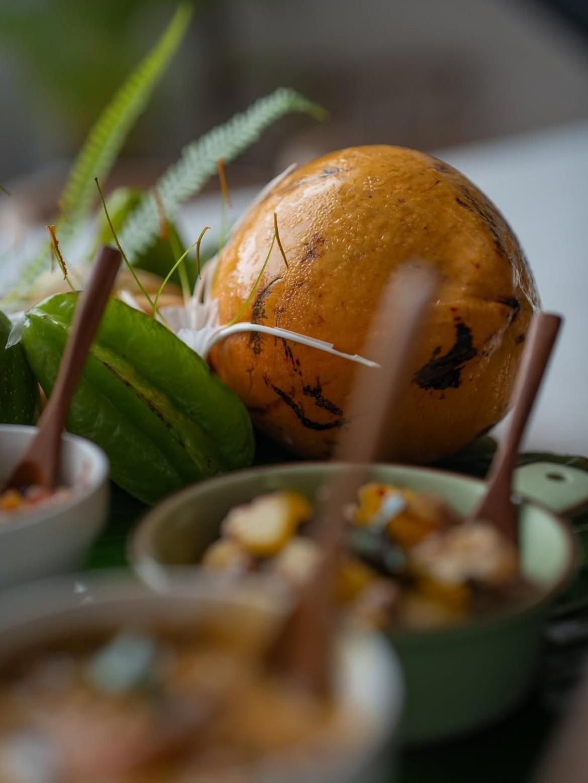 A king coconut beside bowls of curry