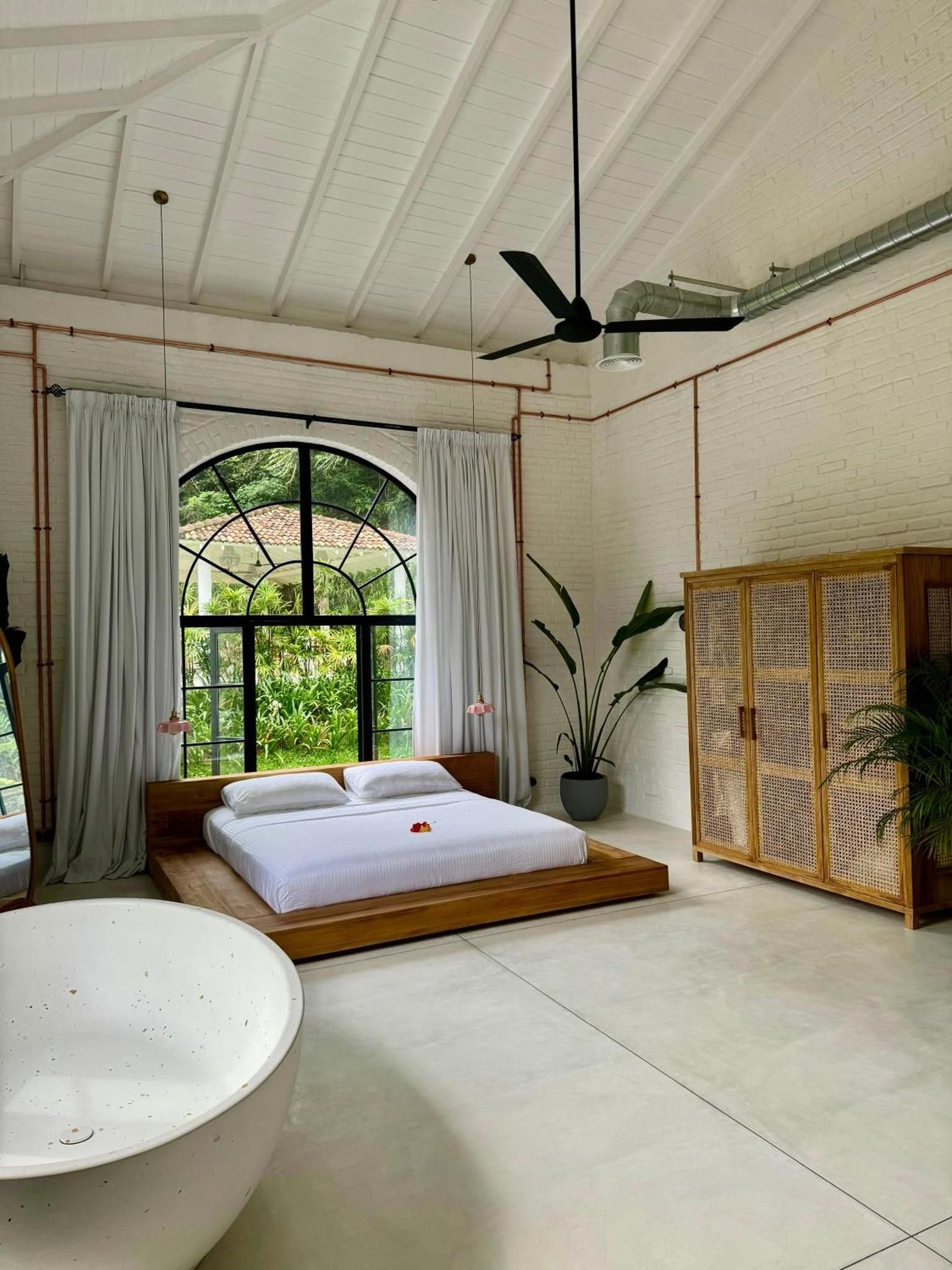 A loft with a terrazzo tub and arched window