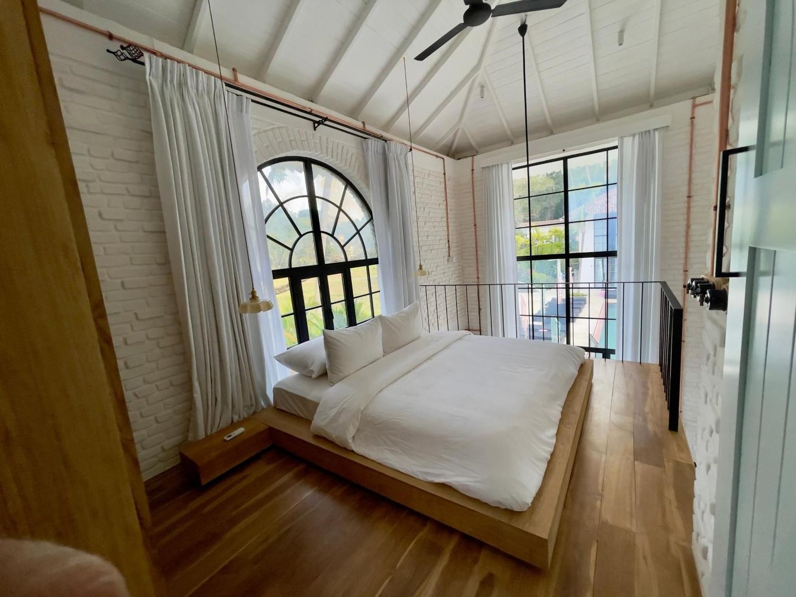 Queen Loft: A loft with a raised mezzanine bedroom, steel-framed windows onto the jungle and a garden rain shower.