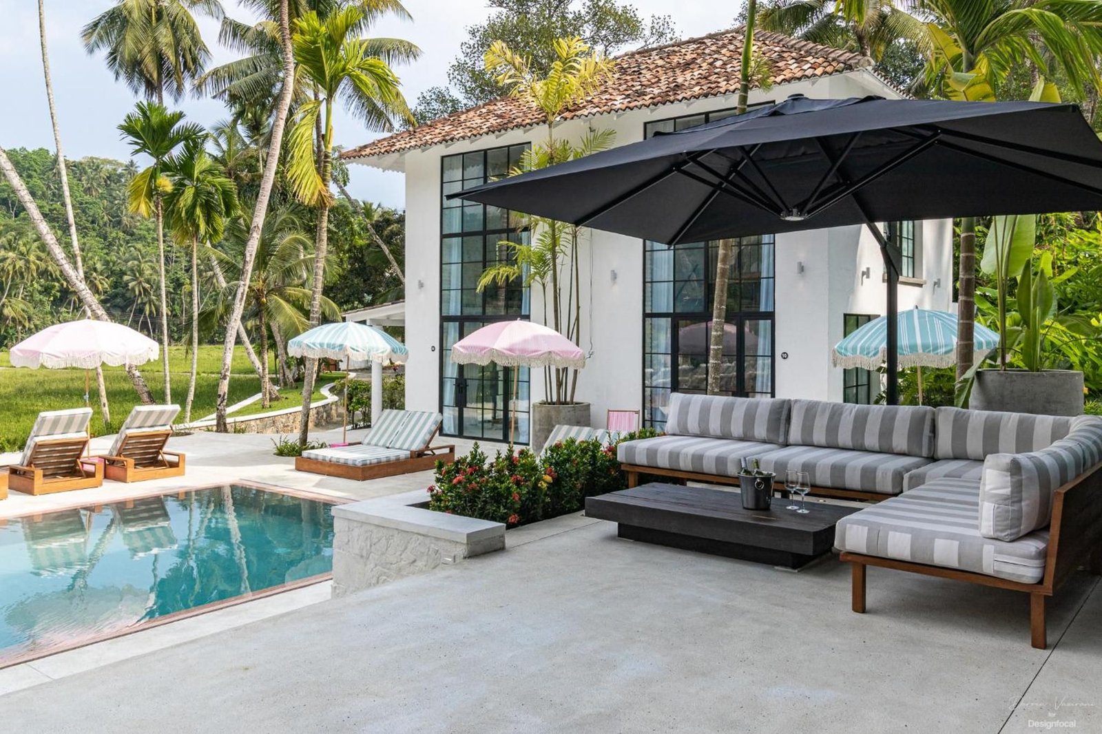 A striped lounge sofa beside the pool