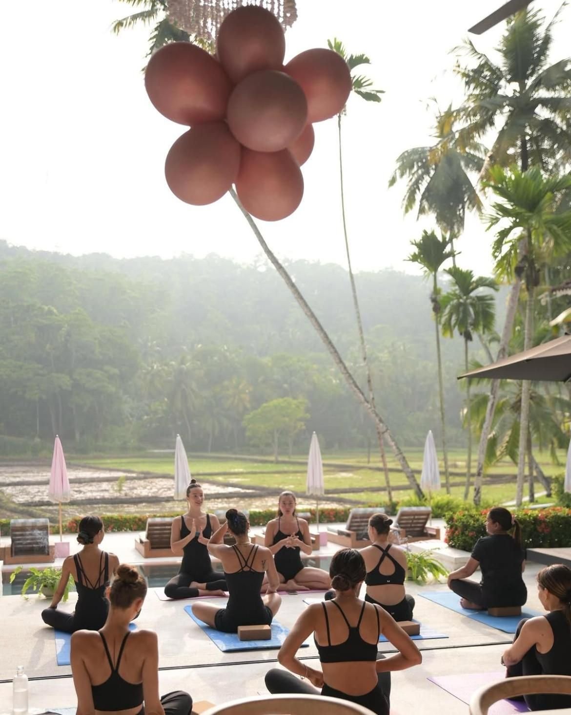 A yoga class on the pool deck beside the rice fields